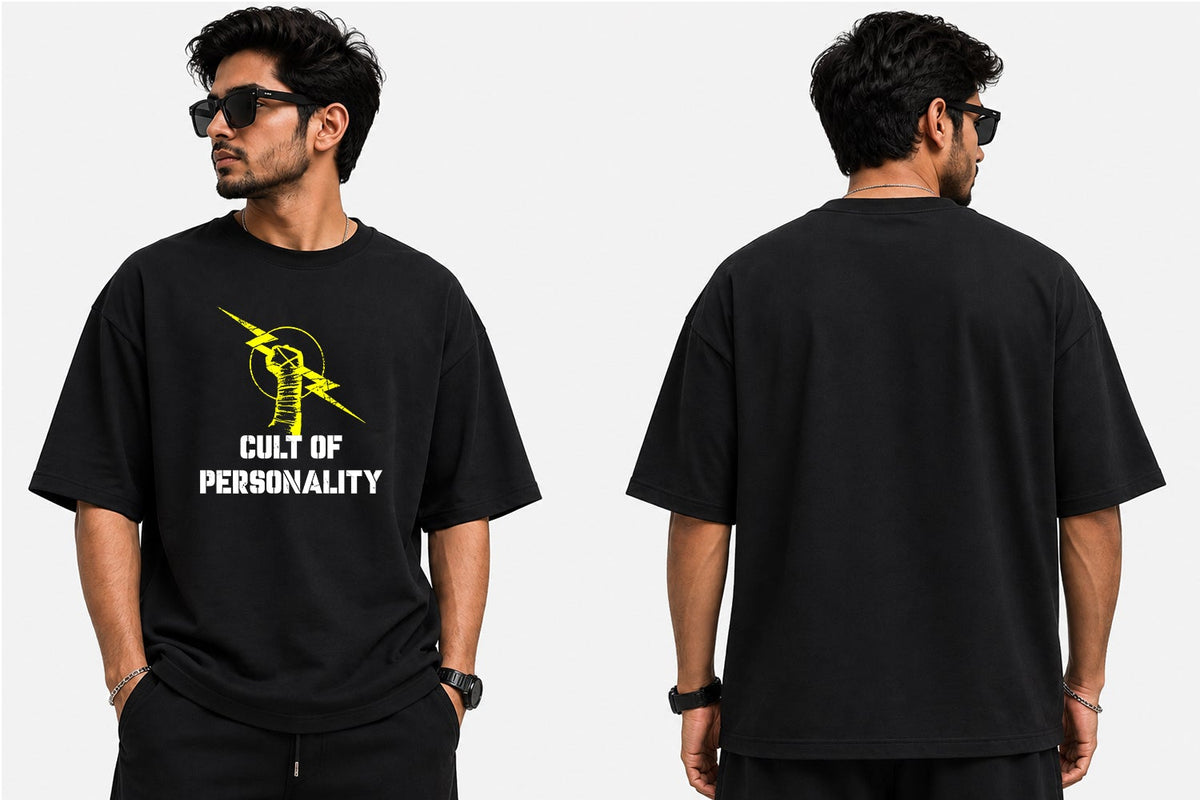 A man modeling a black graphic t-shirt from the front and back against a light gray background. The front of the shirt features a yellow lightning bolt graphic and the text 'CULT OF PERSONALITY' in white.