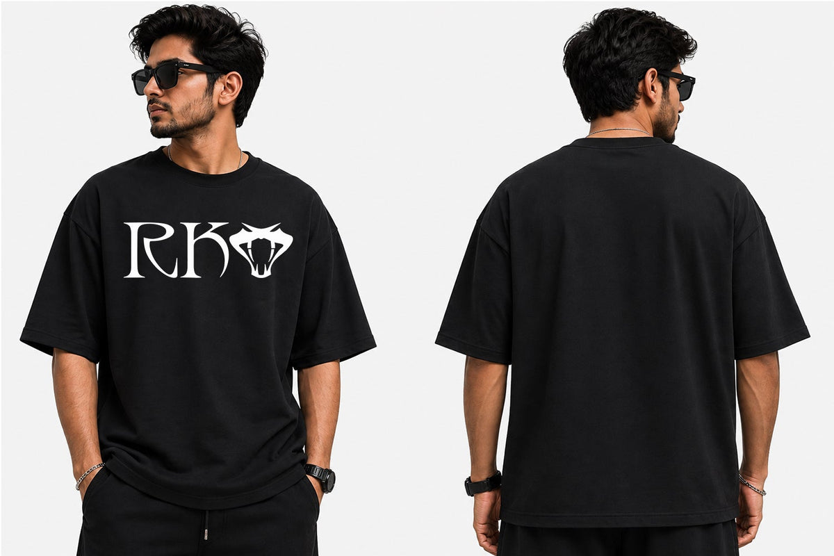 A man modeling a black short-sleeve t-shirt in a studio setting, shown from both the front and back views. The front features a white graphic print with the letters 'RKO' and a diamond icon, while the back is plain black.